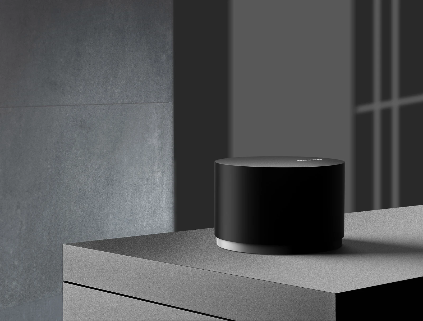 The black MagicDot controller on a graphite console, with soft window shadows on the wall